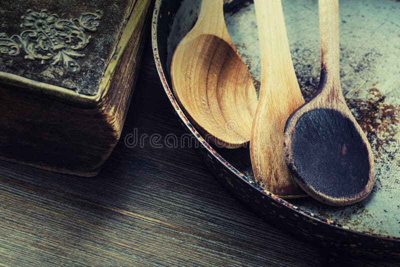 Utensilios de madera de la cocina en la tabla Cuchara de madera del libro de la receta en un estilo retro en la tabla de madera fotos de archivo Utensilios de madera de la cocina en la tabla Cuchara de madera del libro de la receta en un estilo retro en la tabla de madera fotos de archivo