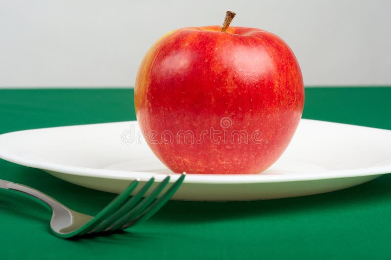 Utensils and red apple
