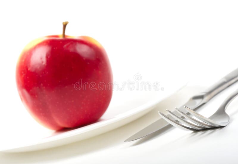 Utensils and red apple