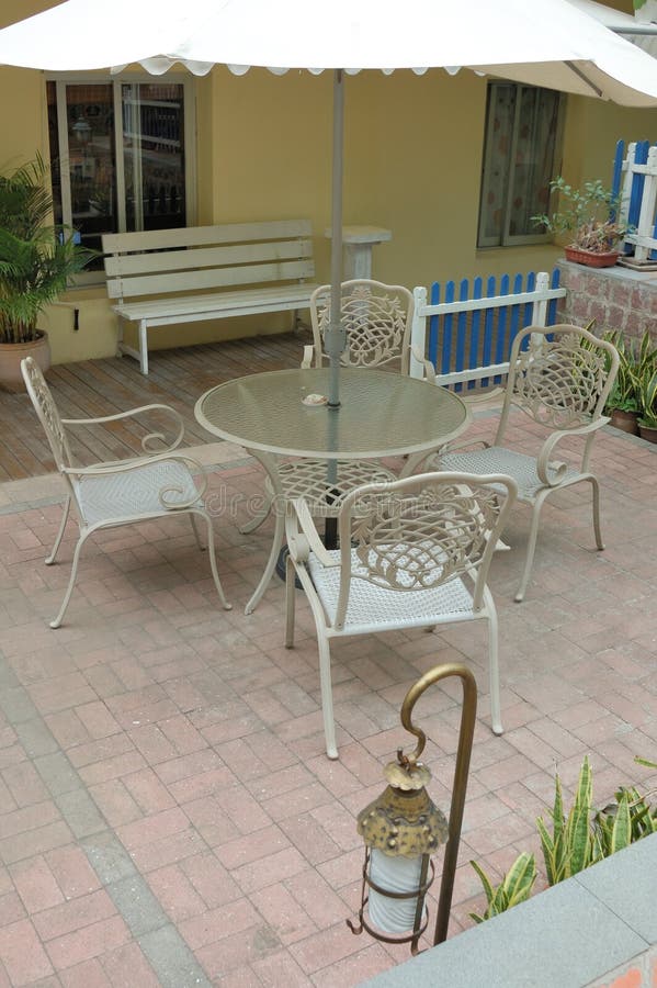 Patio with table and cane chair in a backyard. Patio with table and cane chair in a backyard