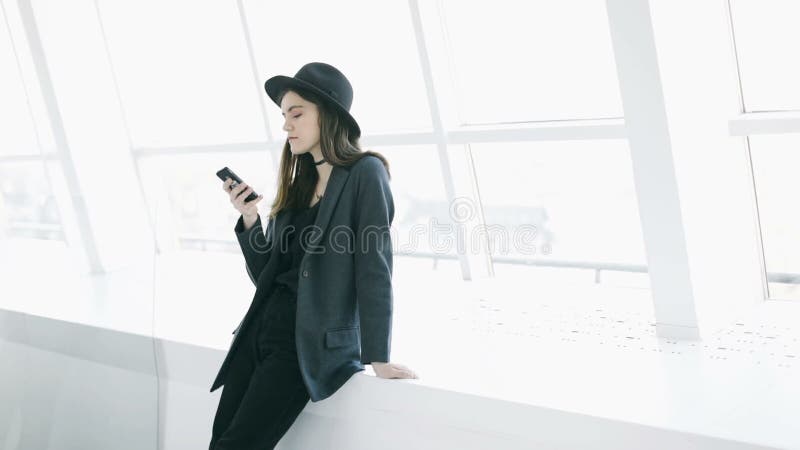 Utilisant la jeune belle femme de téléphone portable dans l'intérieur blanc léger Enregistrement vid? o banque de vidéos