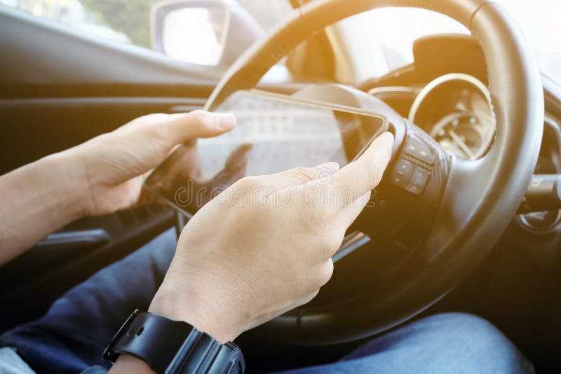 Utilisant le comprimé numérique tout en conduisant la voiture photos stock Utilisant le comprimé numérique tout en conduisant la voiture photos stock