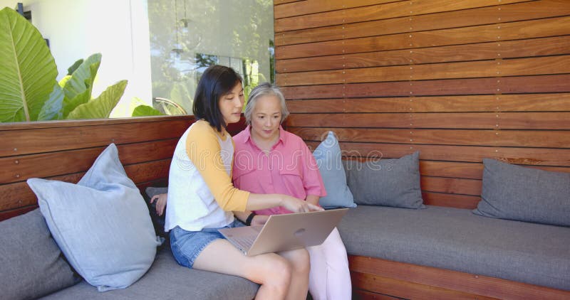 Utilisation d'ordinateur portable jeune asiatique femme et senior asiatique femme discuter de quelque chose à l'écran banque de vidéos