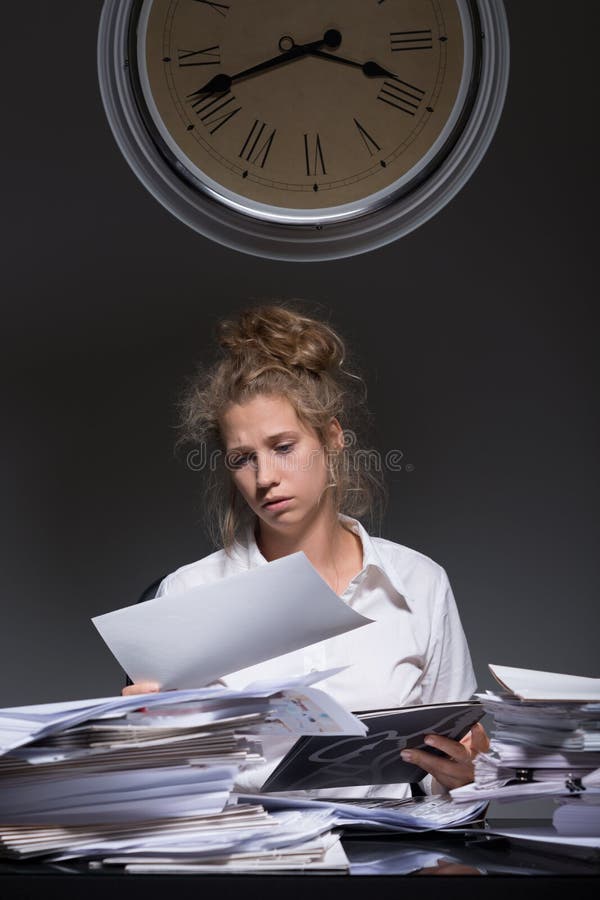 Image of young exhausted office worker doing paperwork. Image of young exhausted office worker doing paperwork