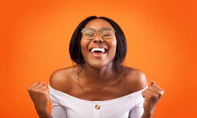 Utmärkt afrikansk dam Gesturing Ja som står över Orange-bakgrunden fotografering för bildbyråer