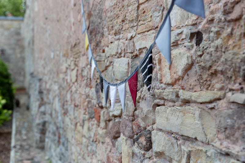 Utomhus- byggande tegelstenvägg som dekoreras med flaggor för tappningtygmedeltal Festival berömbegrepp arkivfoton Utomhus- byggande tegelstenvägg som dekoreras med flaggor för tappningtygmedeltal Festival berömbegrepp arkivfoton