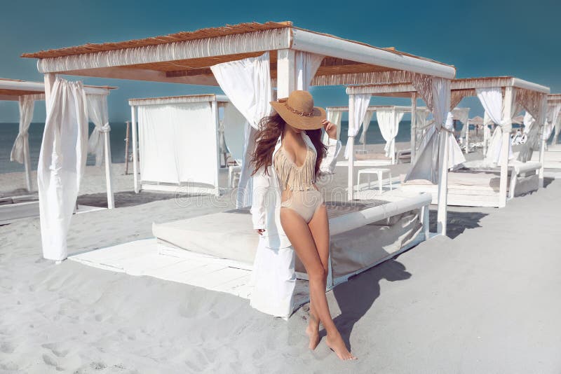 Utomhus- modefoto av den sexiga bikinimodellen i sugrörhatt på tropi royaltyfri fotografi