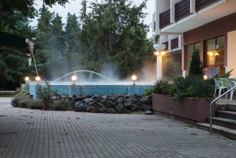 Utomhus- pöl med den termiska vattenbrunnsorten nära hotellet Vatten röker över pölen Termiskt komplex arkivbild Utomhus- pöl med den termiska vattenbrunnsorten nära hotellet Vatten röker över pölen Termiskt komplex arkivbild