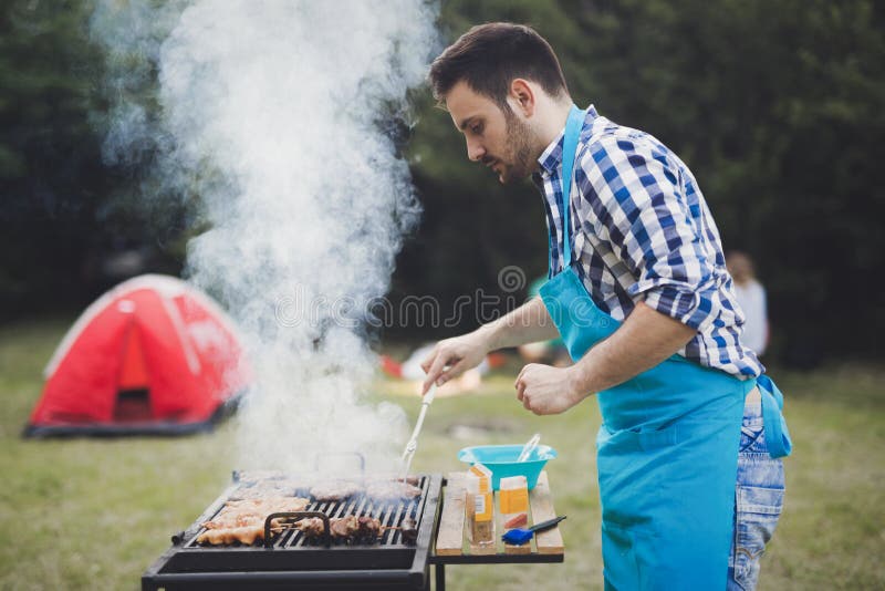 Utomhus- stiligt manligt grilla kött royaltyfria bilder Utomhus- stiligt manligt grilla kött royaltyfria bilder