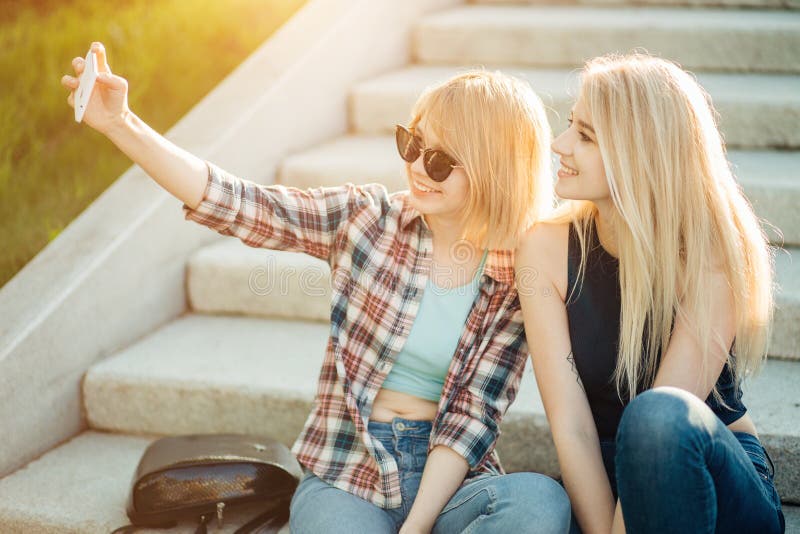 Utomhus- stående för sommar av tre roliga flickor för vänner som tar foto med smartphonen arkivfoto Utomhus- stående för sommar av tre roliga flickor för vänner som tar foto med smartphonen arkivfoto
