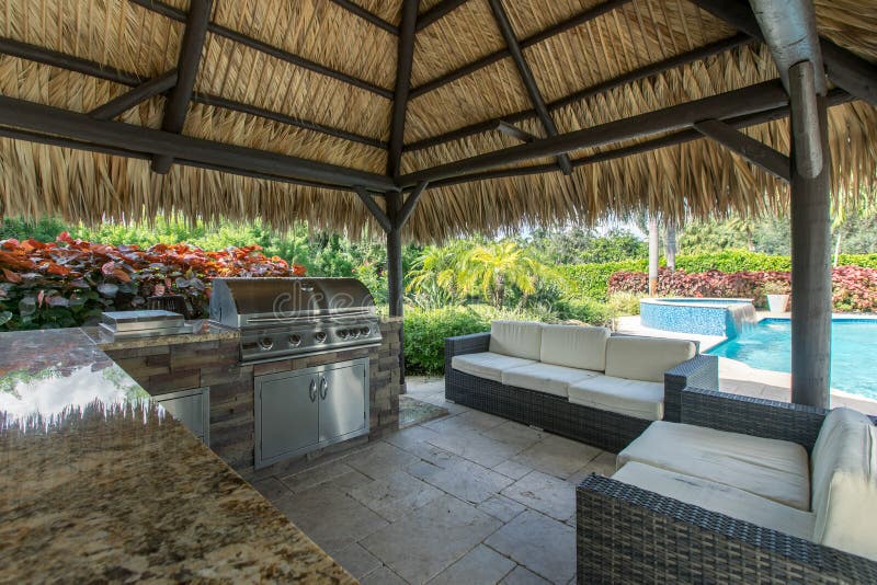 Utomhustiki hut med utomhusgrill, kök och pool royaltyfria foton
