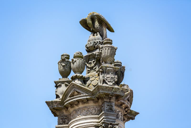 Utsmyckad utomhus- skulptur av örnen som överst matar som är ung av stor pelare utanför domkyrkan i Autun, Bourgogne, Frankrike arkivfoto Utsmyckad utomhus- skulptur av örnen som överst matar som är ung av stor pelare utanför domkyrkan i Autun, Bourgogne, Frankrike arkivfoto