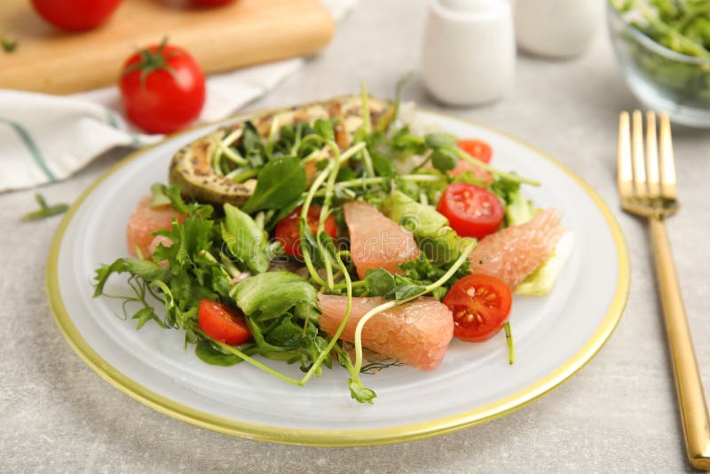 Utsökt pomelosallad med grillad avokado serverad på ljusgrå bordsduk royaltyfria bilder