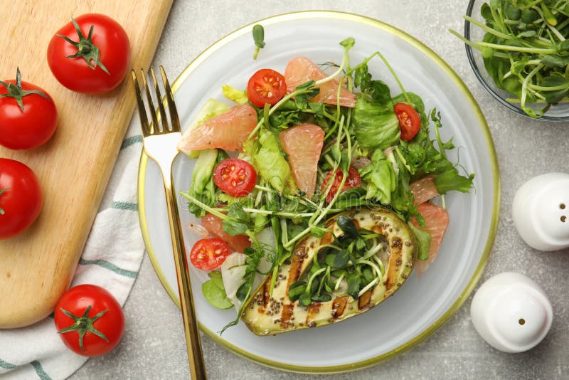 Utsökt pomelosallad med grillad avokado som serveras på lätt grå bordsplack royaltyfri bild