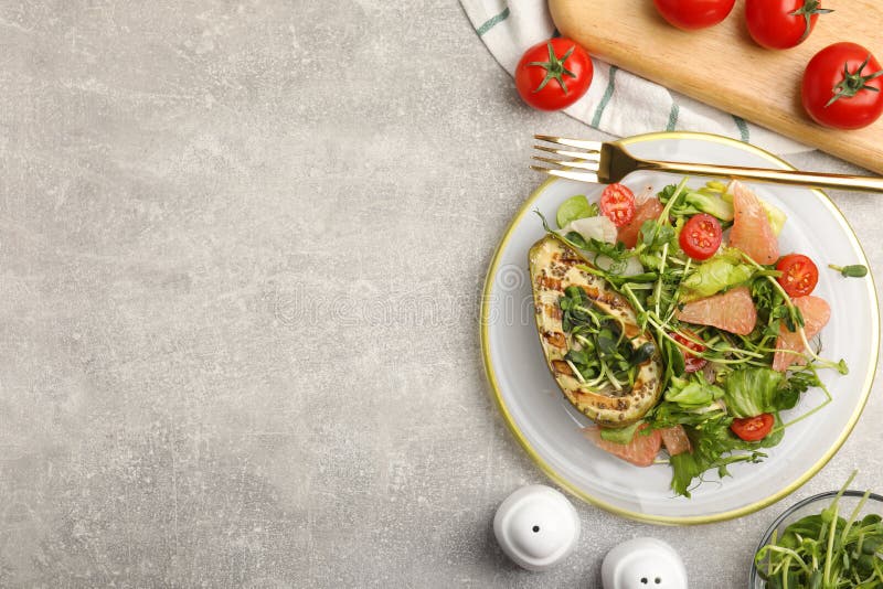 Utsökt pomelosallad med grillad avokado som serveras på lätt grå bordsplack. utrymme för text royaltyfri fotografi