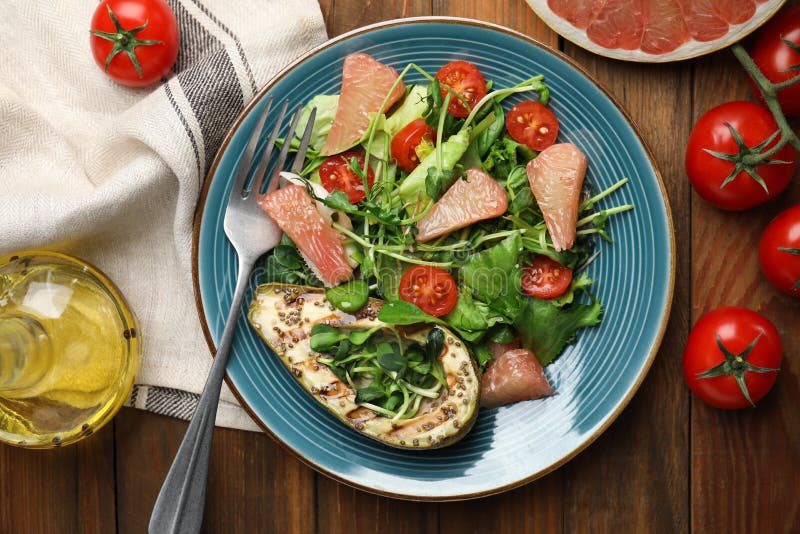Utsökt pomelosallad med grillad avokado som serveras på plattlägg av trä. Utsökt pomelosallad med grillad avokado serverad på träbord