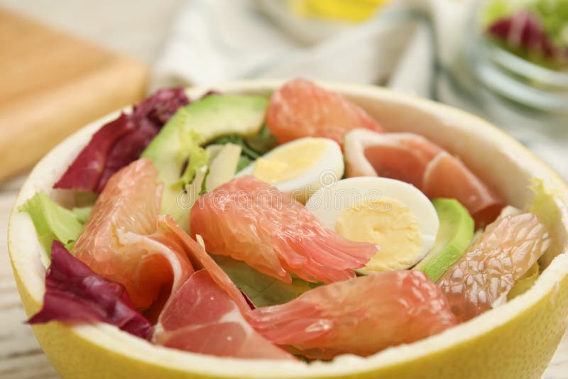 Utsökt pomelosallad med prosciutto i hälften av frukthalten royaltyfri bild