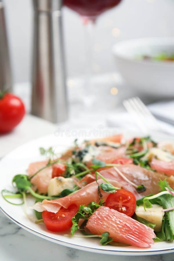 Utsökt pomelosallad med prosciutto serverad på vit marmor bordsduk. utrymme för text royaltyfria foton