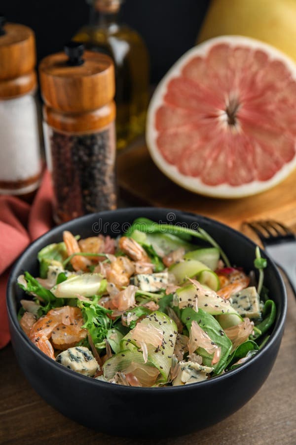 Utsökt pomelosallad med räkor serverade på träbord arkivfoto