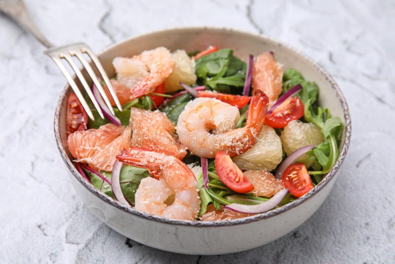 Utsökt pomelosallad med räkor serverade på vit texturerad bordsduk arkivbild
