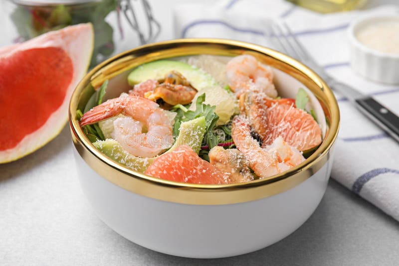 Utsökt pomelosallad med räkor som serveras på ljusgrå bordsduk royaltyfri foto