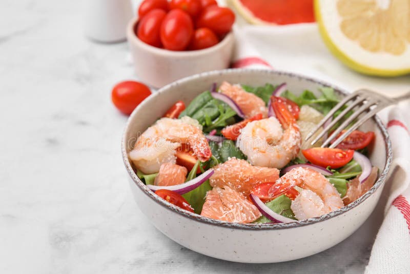 Utsökt pomelosallad med räkor som serveras på vit marmor bordsduk. utrymme för text arkivbild