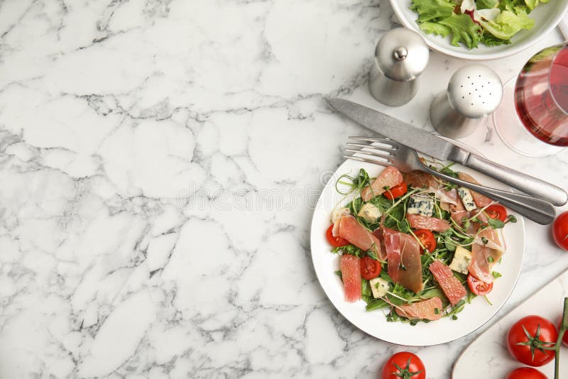 Utsökt pomelosallat med prosciutto serverad på vitt marmorbord med plan botten. utrymme för text royaltyfri fotografi