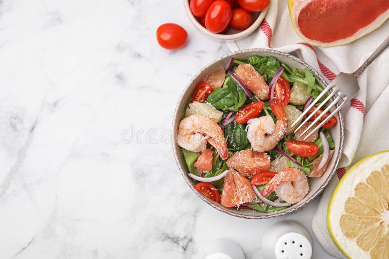 Utsökt pomelossallad med räkor som serveras på vitt marmorbord med plant lägg. utrymme för text arkivfoto