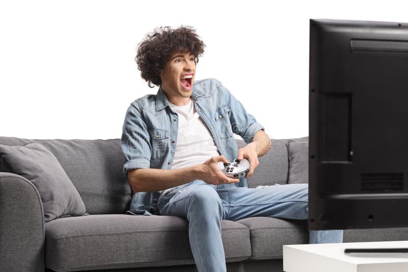 Utsökt ung man som sitter på soffan och spelar videospel royaltyfri bild
