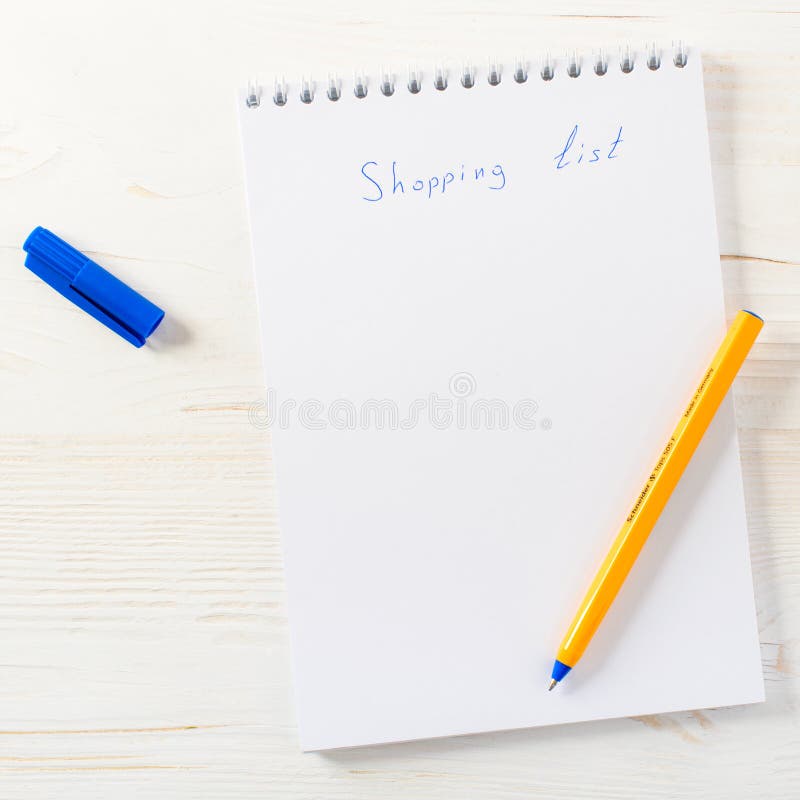 Uttryck för shoppinglista i notepad med pennan på den ljusa trätabellen, arkivbild Uttryck för shoppinglista i notepad med pennan på den ljusa trätabellen, arkivbild