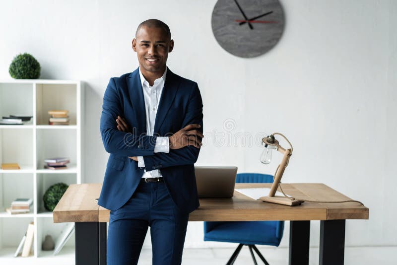 Utövande affärsman för stilig gladlynt afrikansk amerikan på workspacekontoret royaltyfri foto