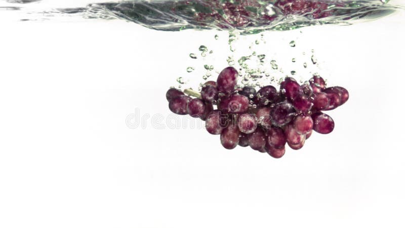 Uvas a salpicar na água em super câmara lenta filme