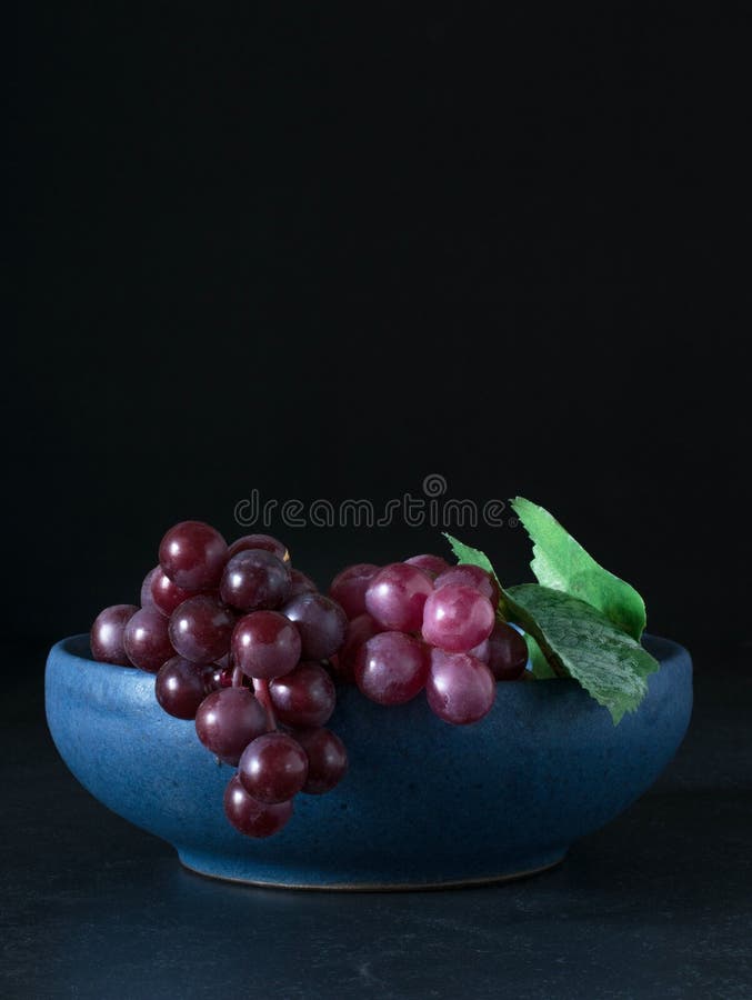 Uvas vermelhas em uma bacia azul fotografia de stock royalty free Uvas vermelhas em uma bacia azul fotografia de stock royalty free