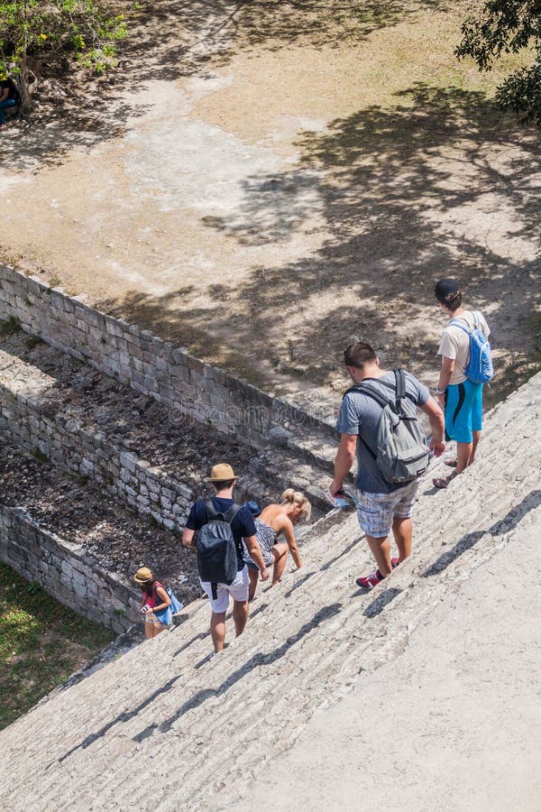 UXMAL, MÉXICO - 28 DE FEVEREIRO DE 2016: Os turistas descem da pirâmide grande nas ruínas da cidade maia antiga Uxmal, Mexi foto de stock royalty free UXMAL, MÉXICO - 28 DE FEVEREIRO DE 2016: Os turistas descem da pirâmide grande nas ruínas da cidade maia antiga Uxmal, Mexi foto de stock royalty free