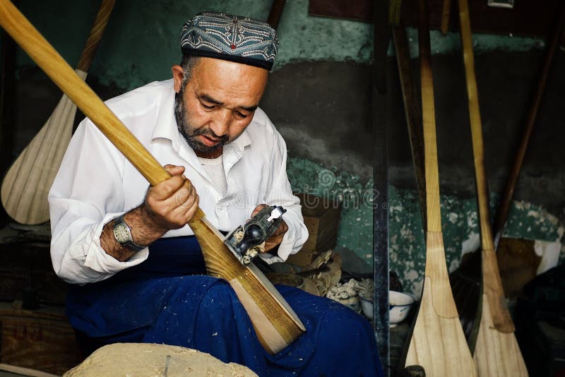 uyghur mens die een instrument genoemd een lokale vioolversie dutar maken stock fotografie uyghur mens die een instrument genoemd een lokale vioolversie dutar maken stock fotografie