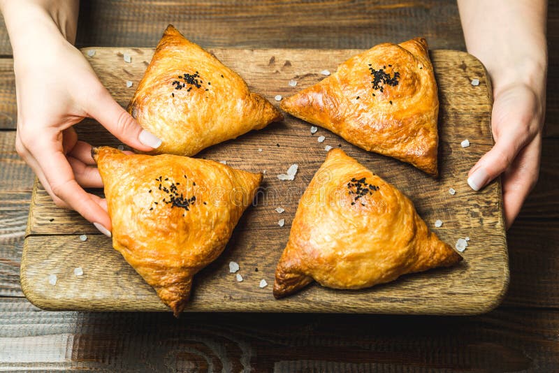 Uzbek National Dish of Samsa on a Wooden Board in the Hands of a Girl ...