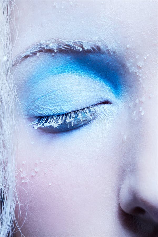 Close-up portrait of beautiful girl's eye-zone fantasy snow make-up. Close-up portrait of beautiful girl's eye-zone fantasy snow make-up