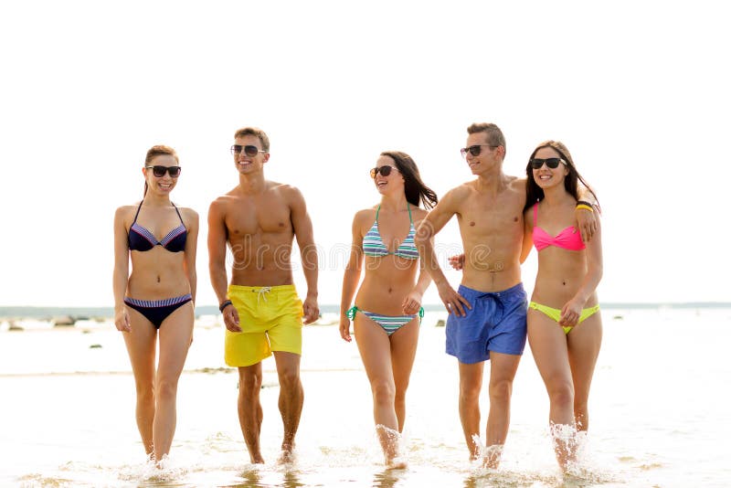 Uśmiechnięci przyjaciele w okularach przeciwsłonecznych na lato plaży fotografia stock
