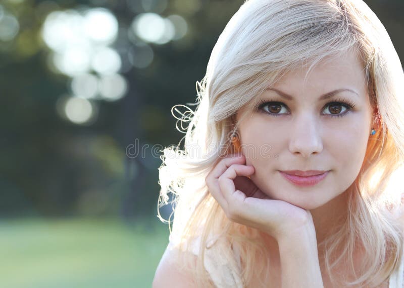 Uśmiechnięta blondynki dziewczyna. Portret szczęśliwa piękna młoda kobieta, outdoors. Bokeh fotografia stock