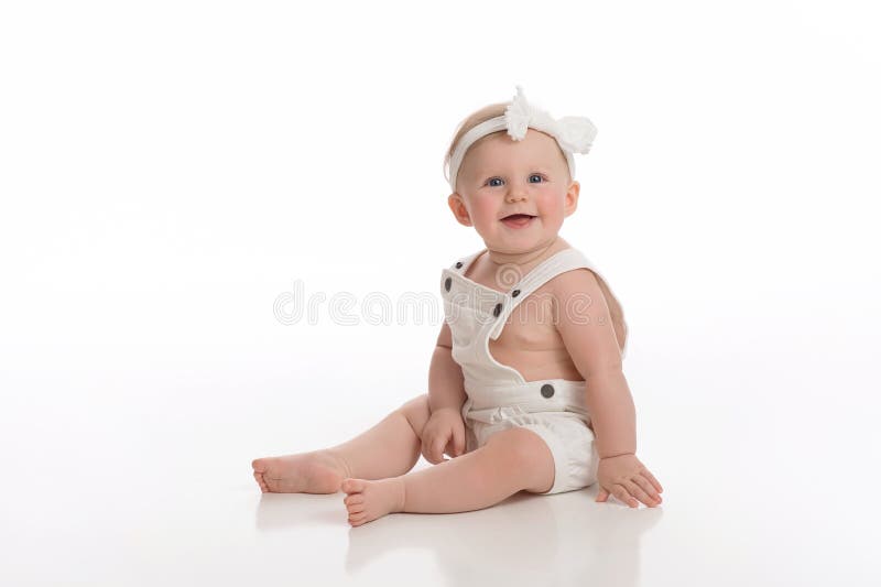 Uśmiechnięta dziewczynka Jest ubranym Białych kombinezony zdjęcie royalty free Uśmiechnięta dziewczynka Jest ubranym Białych kombinezony zdjęcie royalty free