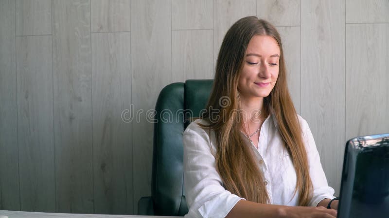 Uśmiechnięta kaukaska kobieta pracująca na laptopie, odwracająca wzrok, myśląc o rozwiązaniu problemu w biurze domowym, podejmuje