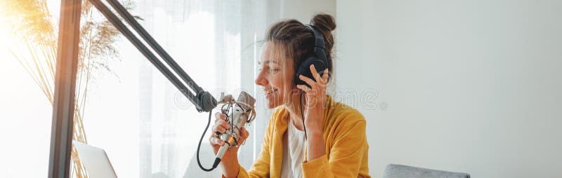 Uśmiechnięta kobieta-gospodarz radia nagrywa i transmituje swój podcast ze studia obraz stock