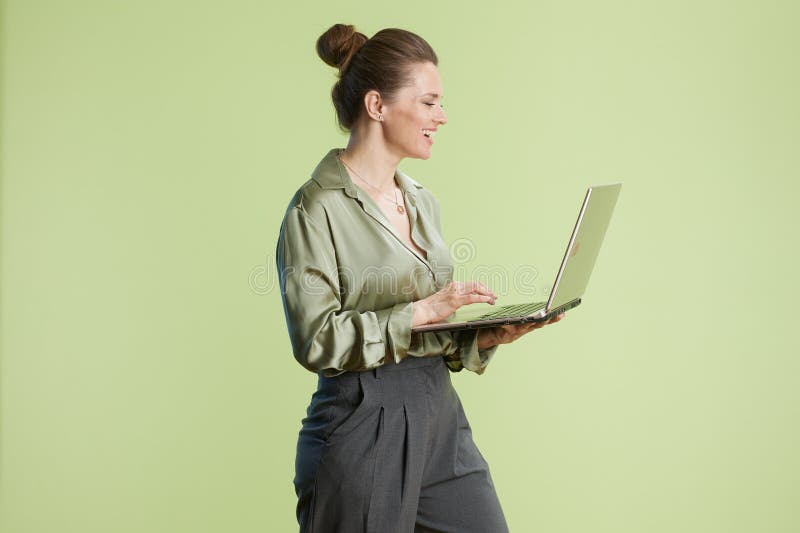 Uśmiechnięta kobieta pracuje na laptopie w jasnym studio zdjęcie stock
