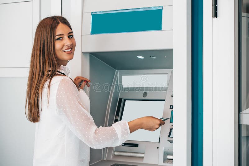 Uśmiechnięta kobieta wycofuje pieniądze od karty kredytowej przy ATM obraz stock Uśmiechnięta kobieta wycofuje pieniądze od karty kredytowej przy ATM obraz stock