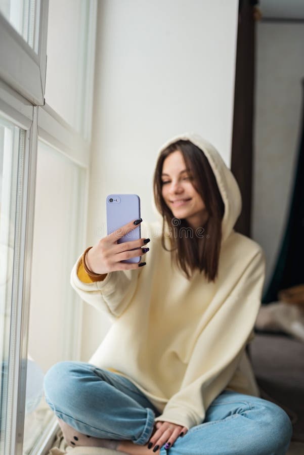 Uśmiechnięta młoda nastolatka telewizja z telefonem komórkowym, rozmawiająca z rodziną przyjaciół, zabierająca selfie dla mediów s zdjęcie stock