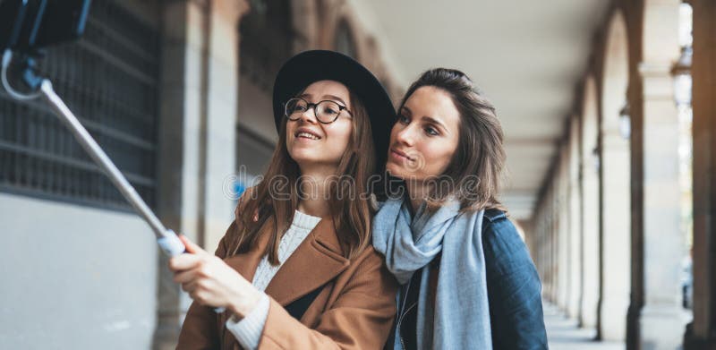 Uśmiechnięte dziewczyny robiące zdjęcie selfie na smartfonie Bloger podróżuje razem w Barcelonie Przyjaźń wakacyjna obrazy stock Uśmiechnięte dziewczyny robiące zdjęcie selfie na smartfonie Bloger podróżuje razem w Barcelonie Przyjaźń wakacyjna obrazy stock