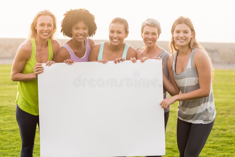 Uśmiechnięte sporty kobiety trzyma plakatowymi z kopii przestrzenią zdjęcie royalty free