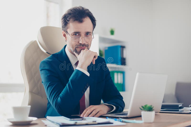 Uśmiechnięty biznesmena bankowiec siedzi przy jego looki i miejscem pracy zdjęcie stock Uśmiechnięty biznesmena bankowiec siedzi przy jego looki i miejscem pracy zdjęcie stock
