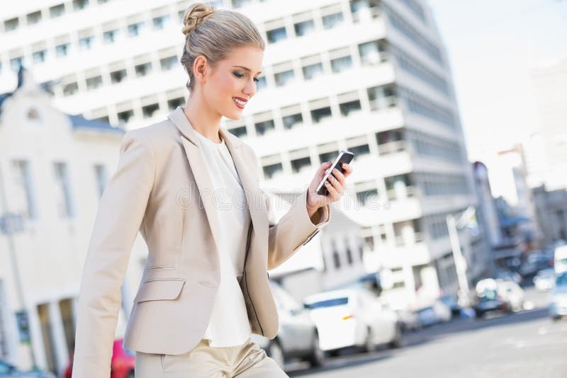 Uśmiechnięty wspaniały bizneswomanu wysylanie sms fotografia stock Uśmiechnięty wspaniały bizneswomanu wysylanie sms fotografia stock
