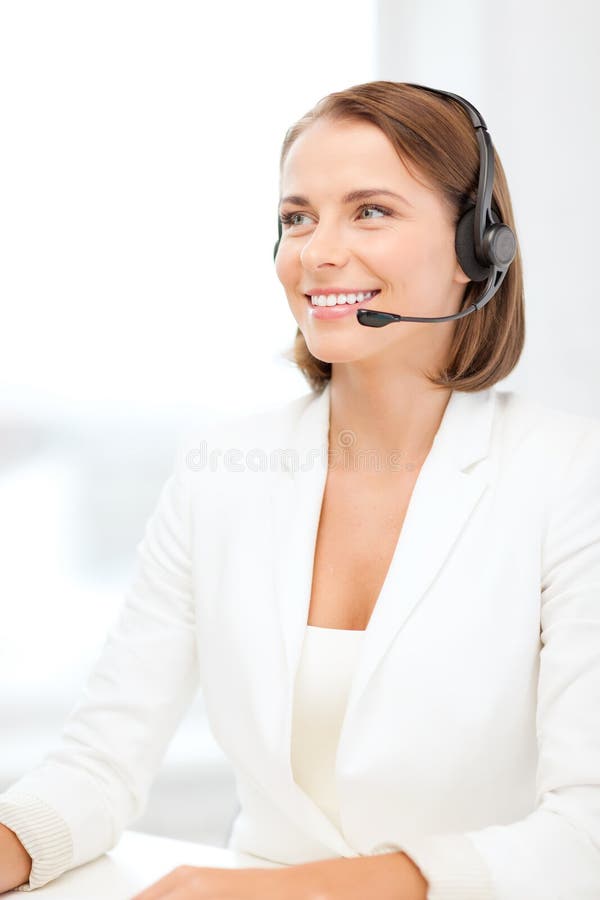 Uśmiechnięty żeński helpline operator z hełmofonami fotografia stock Uśmiechnięty żeński helpline operator z hełmofonami fotografia stock